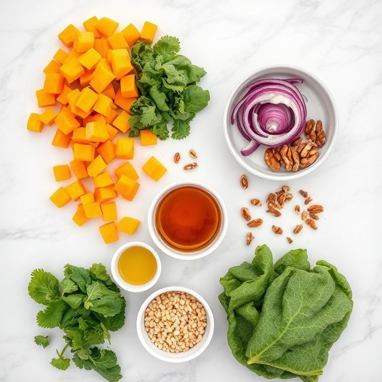 Flat lay of pearl couscous, butternut squash, kale, onion, and dressing ingredients on a white marble surface