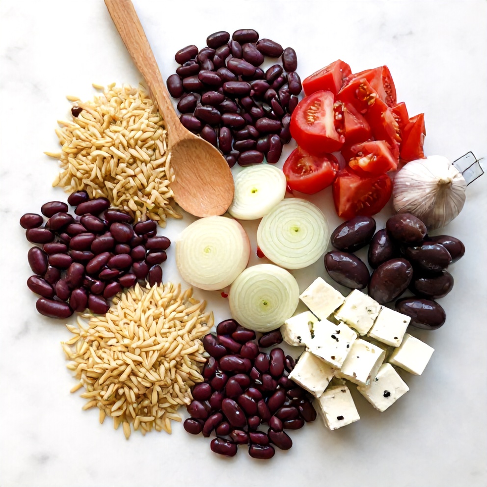 Raw ingredients for Mediterranean Orzo and Beans One-Pot Dinner on a marble surface