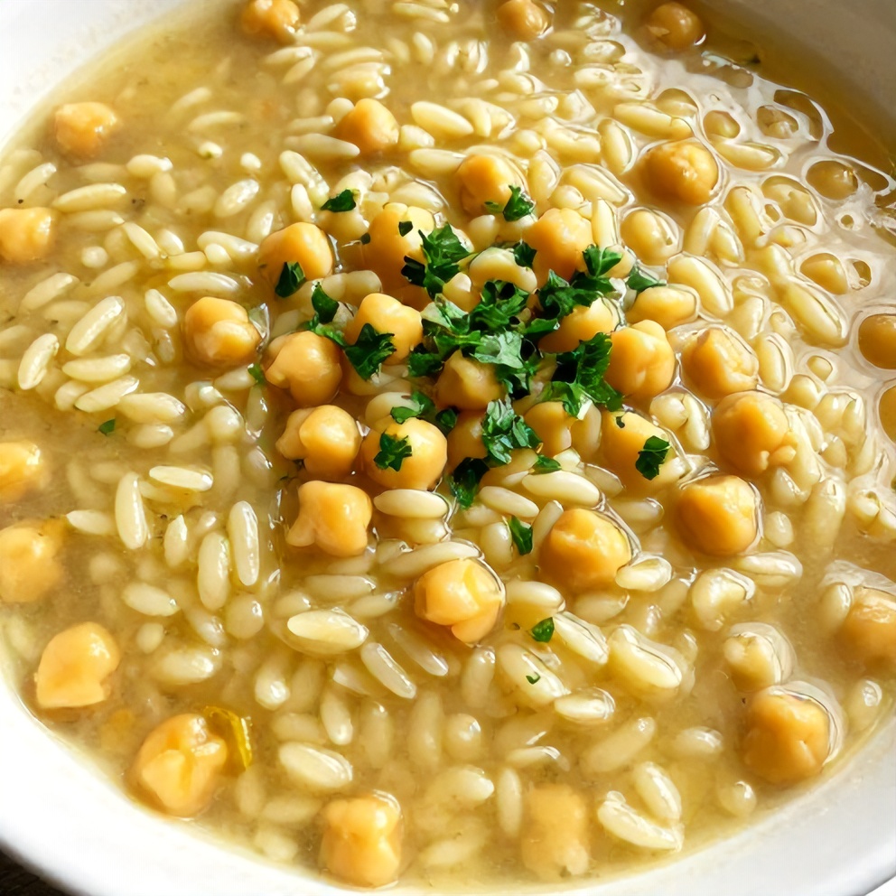 Bowl of Lemon Chickpea Orzo Soup with a sprinkle of parsley
