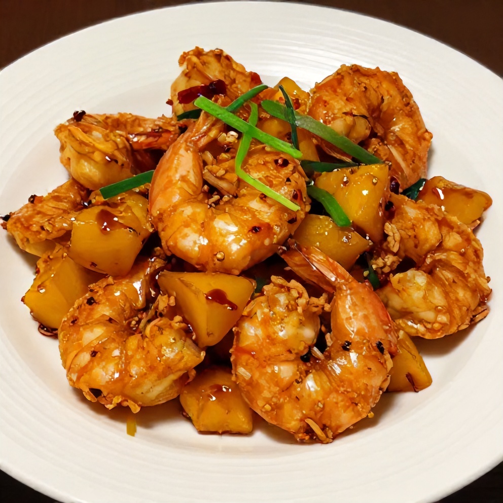 Crispy Sweet Chili Pineapple Shrimp on a white plate with green onions